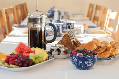 a table topped with bowls of fruit and pastries at Leverton House in Cambridge