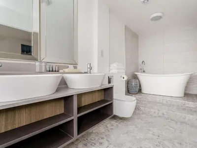 a bathroom with two sinks and a tub and a toilet at Pike & Eel Hotel and Marina in Needingworth