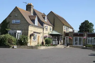 a large house with a driveway in front of it at Pike & Eel Hotel and Marina in Needingworth