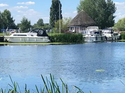 a group of boats are docked on a lake at Pike & Eel Hotel and Marina in Needingworth
