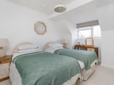 two beds in a white room with green blankets at Pike & Eel Hotel and Marina in Needingworth