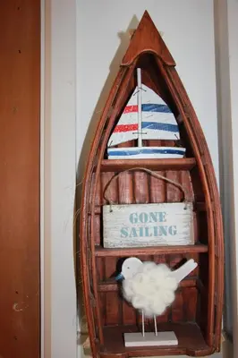 a bird in a wooden shelf with a boat on it at Seaside Fisherman Cottage Aldeburgh in Aldeburgh