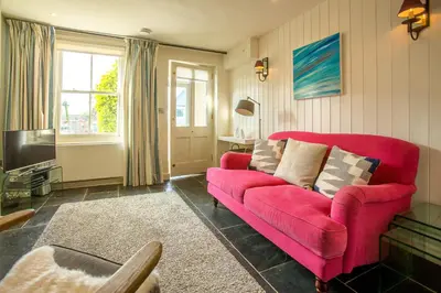 a living room with a red couch and a tv at Nutshell in Aldeburgh