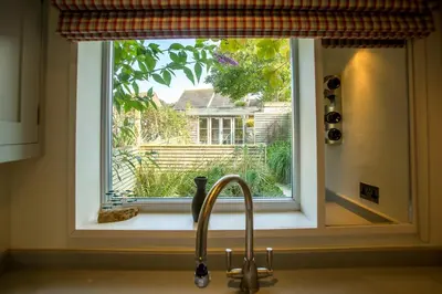 a kitchen sink with a window over a sink at Nutshell in Aldeburgh