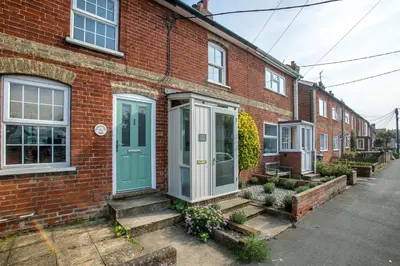 a brick house with a green door on a street at Nutshell in Aldeburgh