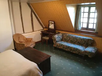 a bedroom with a bed and a couch and a desk at Cross Keys Hotel Chatteris in Chatteris