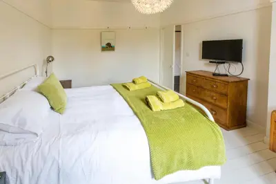 a bedroom with a white bed with two yellow pillows at Watermans in Aldeburgh
