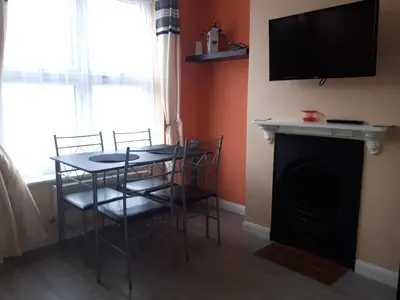 a dining room with a table and chairs and a fireplace at St Giles, Thetford, 2BR House in Thetford