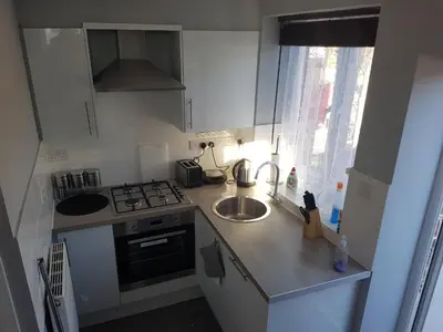 a small kitchen with a sink and a stove at St Giles, Thetford, 2BR House in Thetford