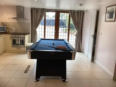 a pool table in the middle of a kitchen at The little house in West Hanningfield