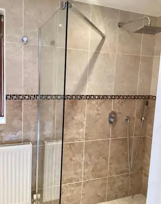 a shower with a glass door in a bathroom at The little house in West Hanningfield