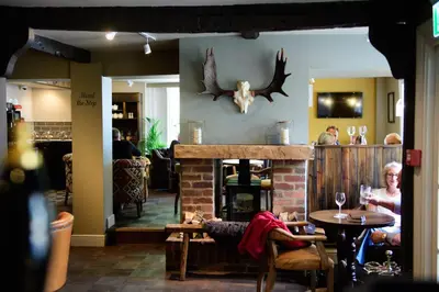 a person sitting at a table in a restaurant at The White Horse in Hertingfordbury