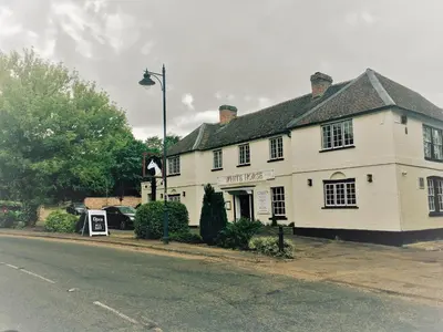 a white building on the corner of a street at The White Horse in Hertingfordbury