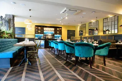 a restaurant with blue chairs and a bar at The White Horse in Hertingfordbury