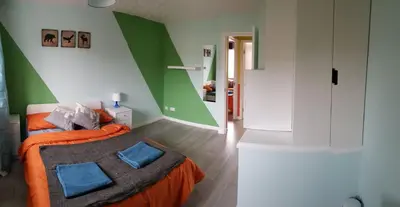 a green and white bedroom with a bed with blue pillows at Columbine, Thetford, 2BR House in Thetford