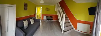 a living room with yellow and orange walls and stairs at Columbine, Thetford, 2BR House in Thetford