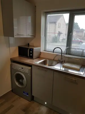 a kitchen with a sink and a washing machine at Columbine, Thetford, 2BR House in Thetford