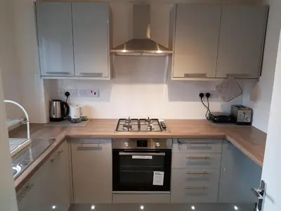 a kitchen with white cabinets and a stove top oven at Columbine, Thetford, 2BR House in Thetford