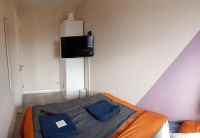 a bedroom with a bed with a tv on the wall at Columbine, Thetford, 2BR House in Thetford
