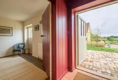 an open door to a room with a patio at Snow Hall Barn in Peasenhall