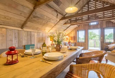 a dining room with a wooden table and chairs at Snow Hall Barn in Peasenhall