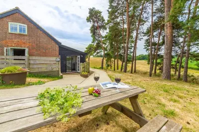 a picnic table with a glass of wine and flowers on it at The Buttery in Freston