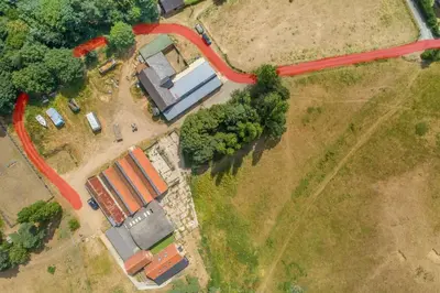 an overhead view of a farm with a red road at The Buttery in Freston