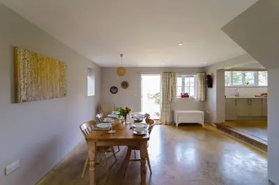 a living room with a wooden table and chairs at The Parlour in Freston
