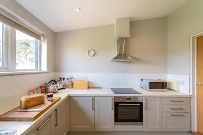 a kitchen with white cabinets and a microwave at The Parlour in Freston