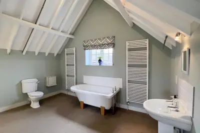 a bathroom with a tub and a toilet and a sink at The Parlour in Freston