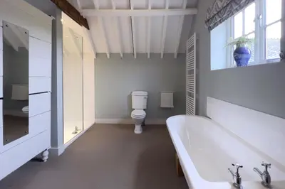a white bathroom with a tub and a toilet at The Parlour in Freston