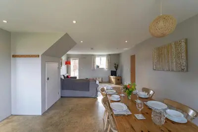 a dining room and living room with a table and chairs at The Parlour in Freston