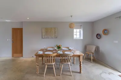 a dining room with a wooden table and chairs at The Parlour in Freston