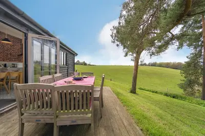 a patio with a table and chairs on a deck at Lodge Farm in Freston