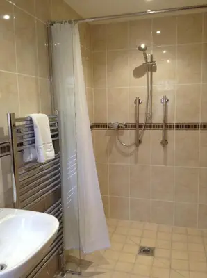 a bathroom with a shower and a sink at The Crown Hotel in Mundford