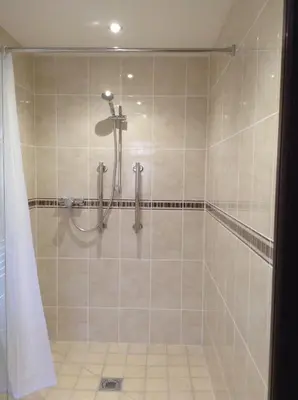 a bathroom with a shower with a shower curtain at The Crown Hotel in Mundford
