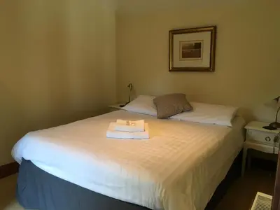 a bedroom with a bed with a towel on it at The Crown Hotel in Mundford
