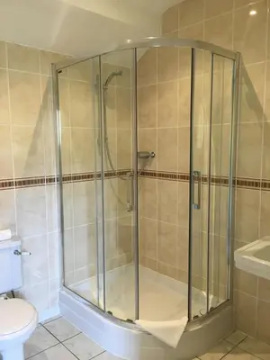a glass shower in a bathroom with a toilet at The Crown Hotel in Mundford