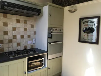 a kitchen with white cabinets and a stove top oven at The Crown Hotel in Mundford