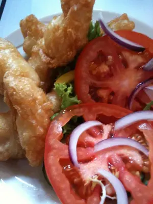a plate of food with tomatoes onion and lettuce at The Crown Hotel in Mundford