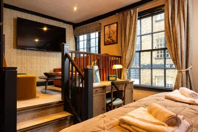 a bedroom with a bed and a desk and window at Salisbury Arms Hotel in Hertford