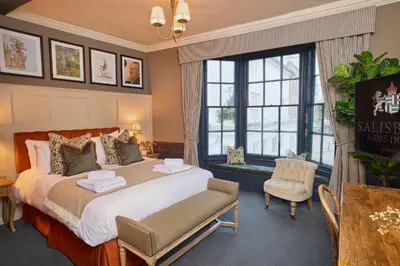 a hotel room with a large bed and a chair at Salisbury Arms Hotel in Hertford