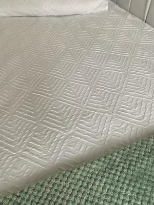 a bed with white sheets and a green carpet at A & B Guest House Cambridge Ltd in Cambridge