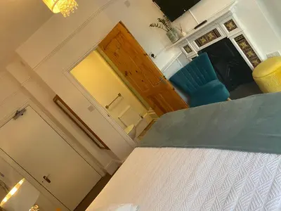 a bedroom with a bed and a blue chair at A & B Guest House Cambridge Ltd in Cambridge