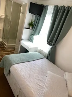 a small bedroom with a bed and a window at A & B Guest House Cambridge Ltd in Cambridge