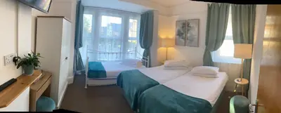 a hotel room with two beds and a window at A & B Guest House Cambridge Ltd in Cambridge
