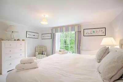 a bedroom with a large white bed and a window at Vicarage House & Pool House in Hockham