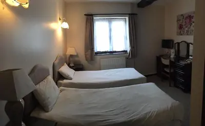 a hotel room with two beds and a window at Sorrel Horse Inn in Ipswich