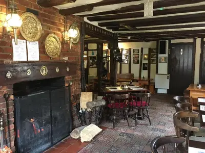 a fireplace in a restaurant with a table and chairs at Sorrel Horse Inn in Ipswich