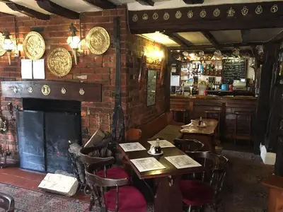 a restaurant with tables and chairs and a fireplace at Sorrel Horse Inn in Ipswich